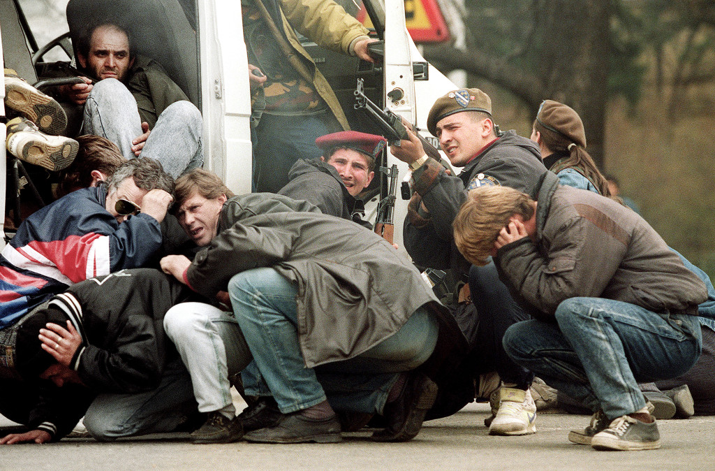 foto : mike persson : to go with afp stories bosnia-war-anniversary (files) in this photo taken on april 6, 1992 a bosnian special forces soldier returns fire in downtown sarajevo as he and civilians come under fire from serbian snipers. the serb extremists were shooting from the roof of a hotel at a peace demonstration of some of 30,000 people as fighting between bosnian and serb fighters escalated in the capital of bosnia-hercegovina. bosnia on april 6, 2012 marks 20 years since the start of a war that has left the country's muslims, serbs and croats deeply divided as some warn it could become europe's failed state. afp photo / mike persson