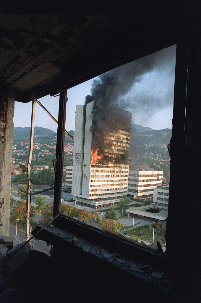 foto : michael evstafiev : to go with bosnia-war-anniversary (files) in this photo taken on september 19, 1992 the former parliament building is seen burning from a destoyed upper floor of the holiday inn hotel in sarajevo after being hit by serbian tank fire. the holiday inn hotel, where most of the western journalists are staying, was also hit by a shell. bosnia on april 6, 2012 marks 20 years since the start of a war that has left the country's muslims, serbs and croats deeply divided as some warn it could become europe's failed state. afp photo michael evstafiev